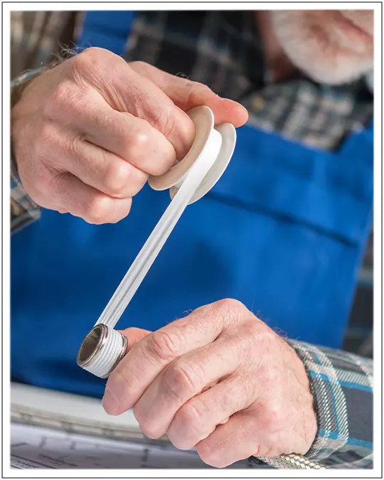 Plumber wrapping Pipe Threads with Thread Seal Tape or Teflon Tape